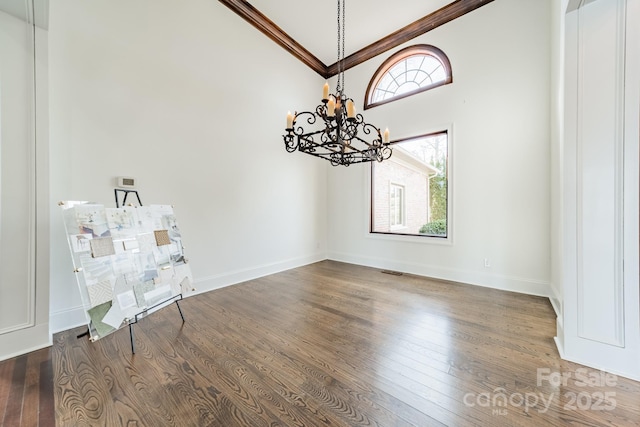 unfurnished dining area with a notable chandelier, wood-type flooring, and vaulted ceiling