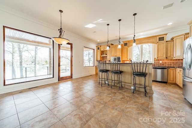 kitchen with a kitchen bar, decorative backsplash, hanging light fixtures, ornamental molding, and stainless steel appliances