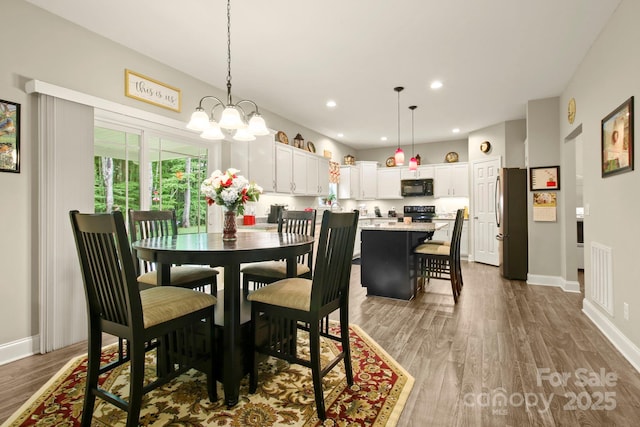 dining room with an inviting chandelier and hardwood / wood-style floors