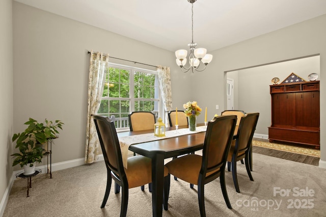 dining space featuring carpet floors and a chandelier