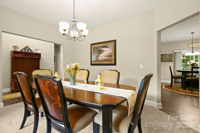 carpeted dining area featuring a chandelier