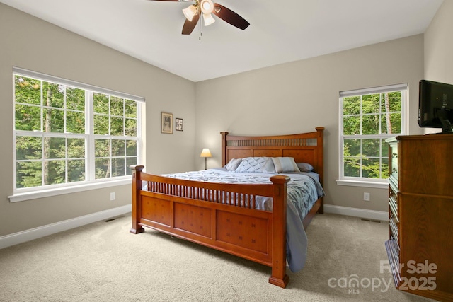 carpeted bedroom with multiple windows and ceiling fan