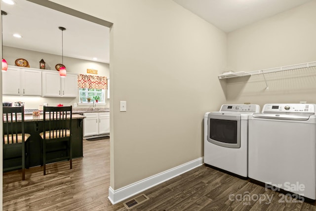 washroom with separate washer and dryer, dark hardwood / wood-style floors, and sink