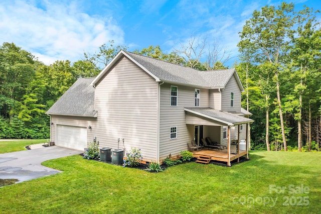 view of home's exterior with a garage, a deck, and a lawn