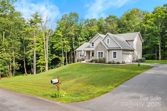 view of front of home with a garage, a front yard, and covered porch