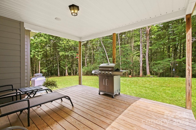 wooden terrace featuring grilling area and a lawn