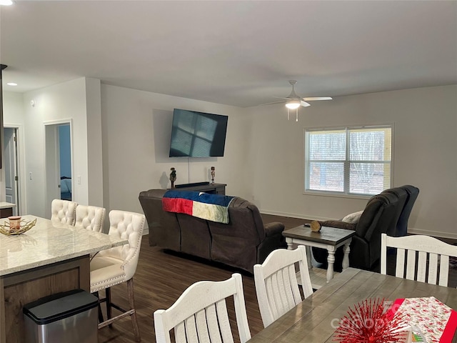 living room with dark wood-type flooring and ceiling fan