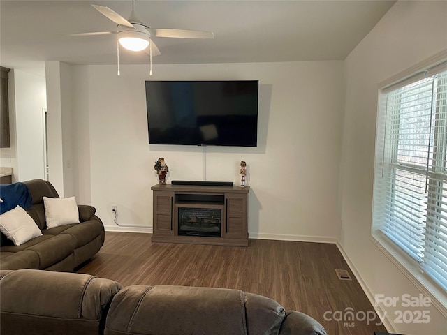 living room featuring ceiling fan and dark hardwood / wood-style floors