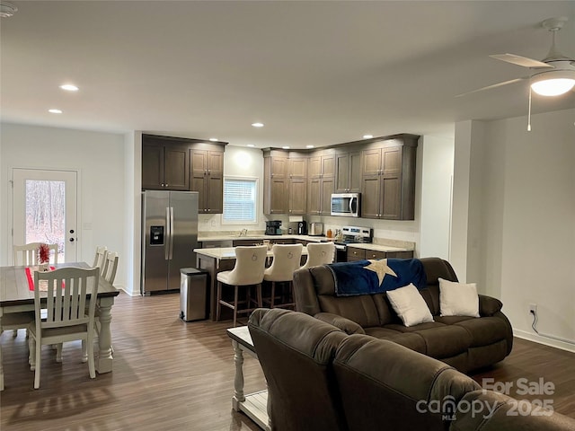 living room featuring ceiling fan, plenty of natural light, and light hardwood / wood-style flooring