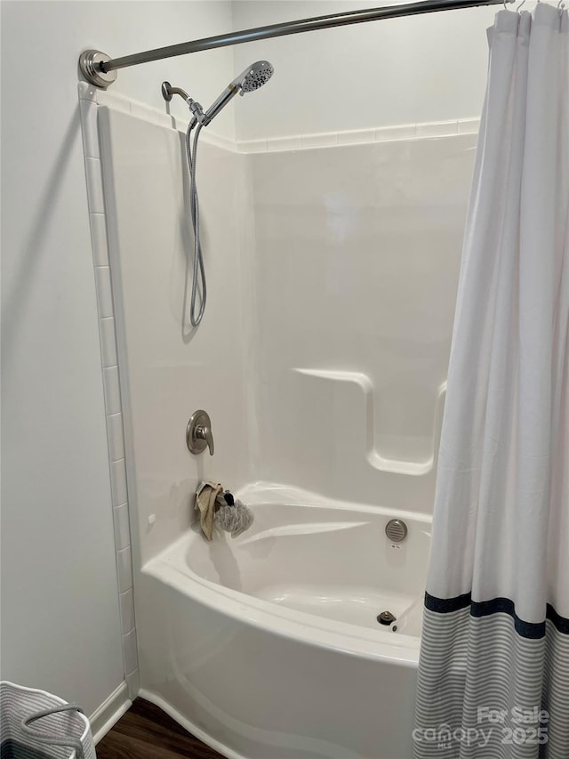 bathroom with wood-type flooring and shower / bathtub combination with curtain