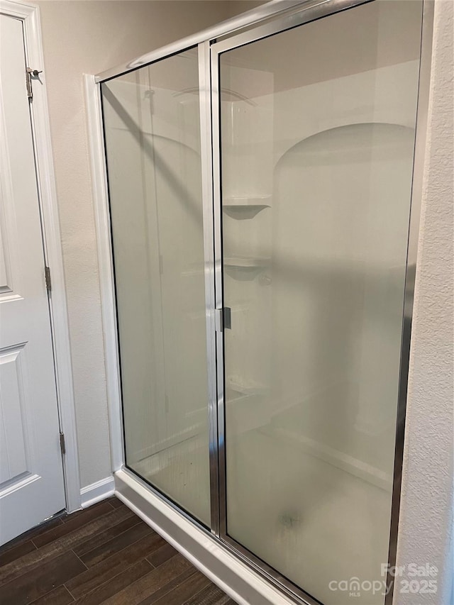 bathroom featuring a shower with shower door and hardwood / wood-style floors