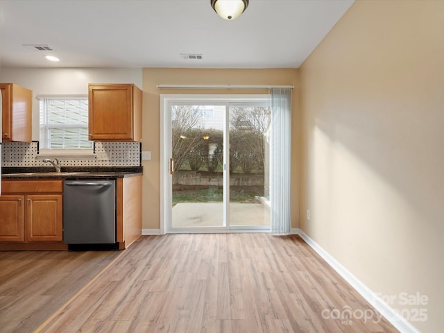 kitchen featuring sink, dishwasher, light hardwood / wood-style floors, and backsplash