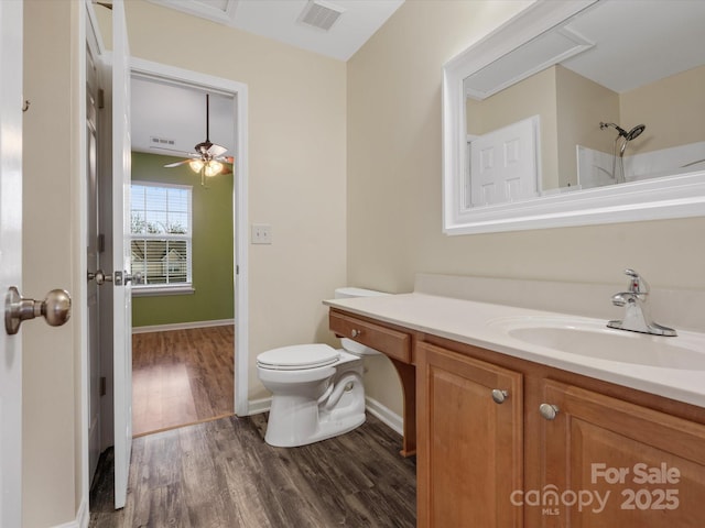 bathroom featuring walk in shower, vanity, toilet, and hardwood / wood-style floors