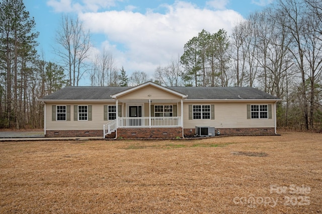 view of front of house with central AC unit, covered porch, and a front yard