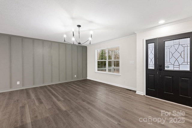 entryway with ornamental molding, hardwood / wood-style floors, and a notable chandelier