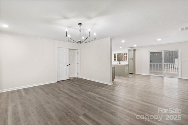 interior space with a notable chandelier, ornamental molding, and hardwood / wood-style floors