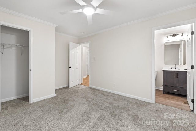 unfurnished bedroom featuring crown molding, ensuite bath, light carpet, a closet, and ceiling fan