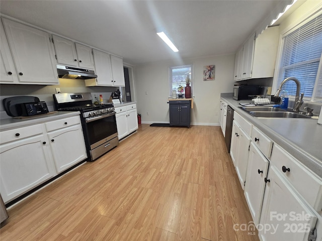 kitchen with sink, light hardwood / wood-style flooring, stainless steel range with gas cooktop, dishwashing machine, and white cabinets