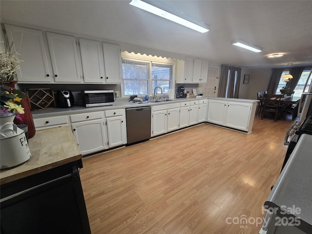 kitchen featuring appliances with stainless steel finishes, sink, white cabinets, and light hardwood / wood-style floors