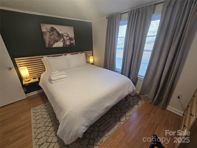 bedroom featuring wood-type flooring and crown molding