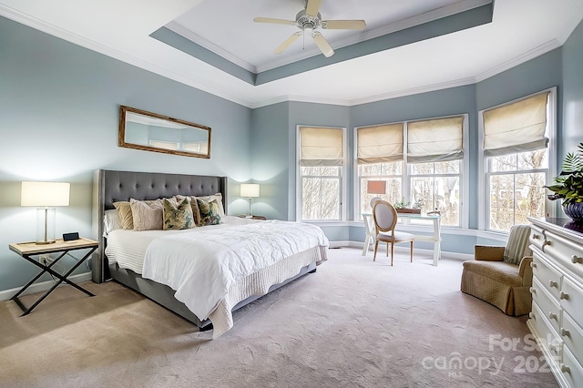 carpeted bedroom with ornamental molding, a raised ceiling, and ceiling fan