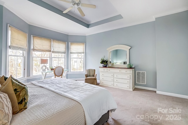 carpeted bedroom with multiple windows, crown molding, a raised ceiling, and ceiling fan