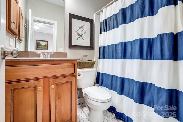 bathroom with tile patterned floors, toilet, vanity, curtained shower, and ceiling fan