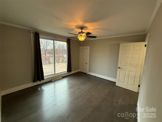 empty room with dark hardwood / wood-style flooring, crown molding, and ceiling fan