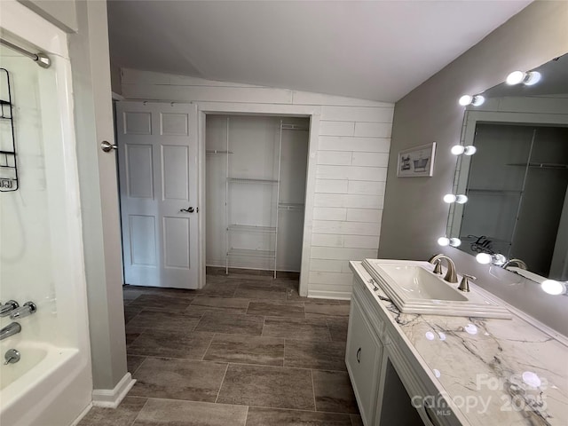 bathroom with vanity, bathing tub / shower combination, and vaulted ceiling