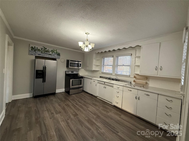 kitchen featuring appliances with stainless steel finishes, white cabinetry, an inviting chandelier, ornamental molding, and dark hardwood / wood-style flooring