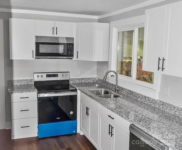 kitchen with light stone counters, stainless steel appliances, sink, and white cabinets