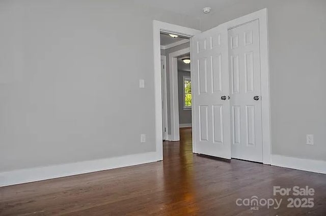 empty room with dark hardwood / wood-style flooring