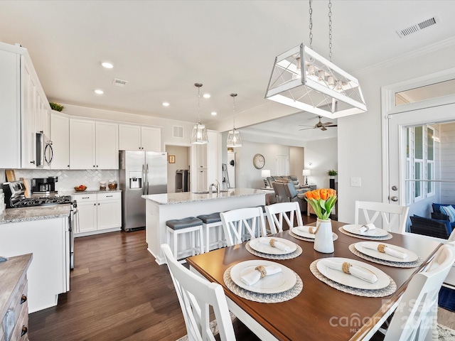 dining room featuring crown molding, dark hardwood / wood-style floors, sink, and ceiling fan