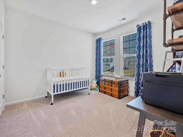 bedroom featuring a nursery area and carpet