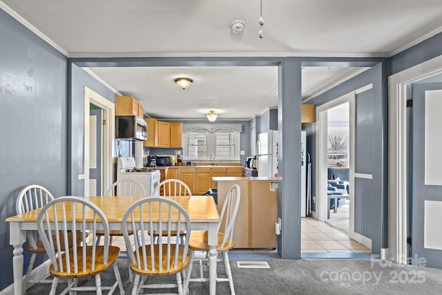 tiled dining room with crown molding and sink