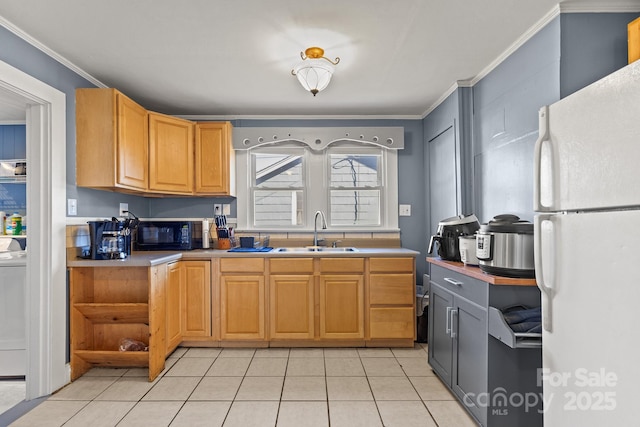 kitchen with sink, crown molding, light tile patterned floors, white refrigerator, and washer / clothes dryer