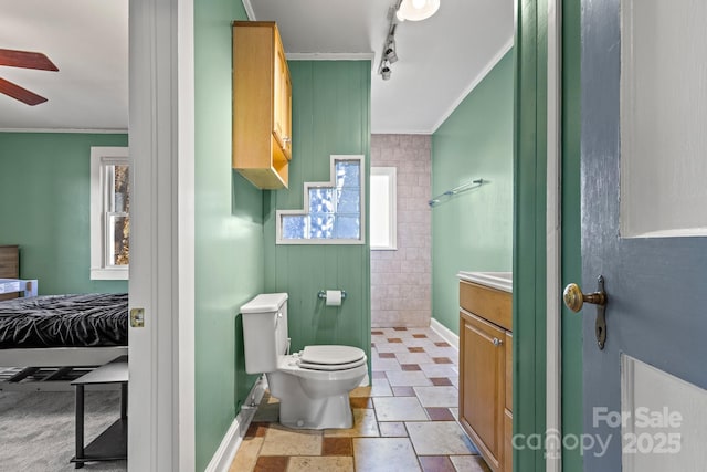 bathroom featuring crown molding, vanity, toilet, and a shower