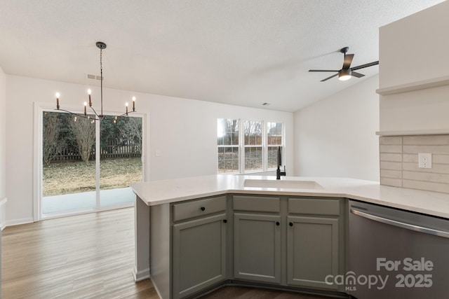 kitchen featuring decorative light fixtures, tasteful backsplash, sink, gray cabinetry, and stainless steel dishwasher