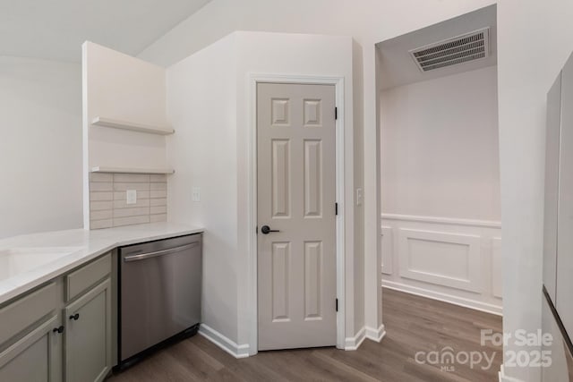 kitchen featuring dishwasher, gray cabinetry, dark hardwood / wood-style floors, tasteful backsplash, and light stone countertops