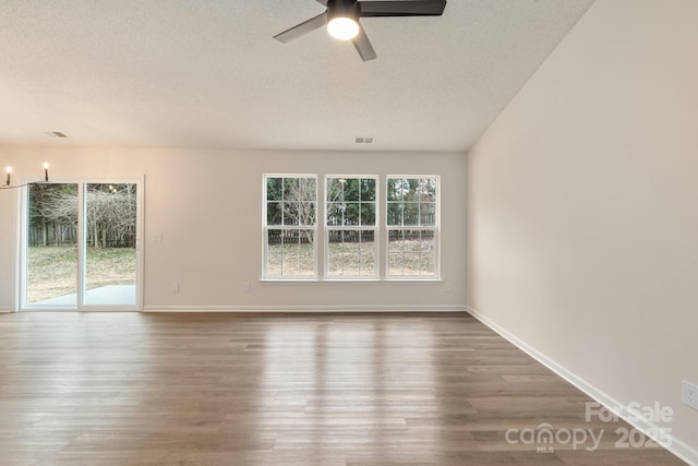 unfurnished room with ceiling fan, dark hardwood / wood-style floors, and a textured ceiling