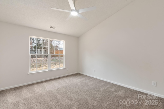 empty room featuring lofted ceiling, carpet flooring, and ceiling fan