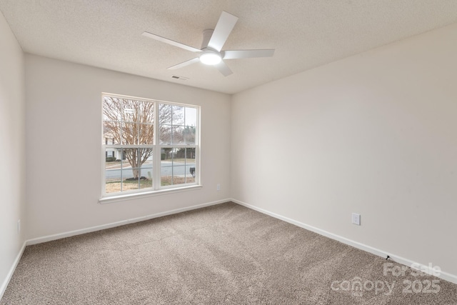 carpeted spare room with a textured ceiling and ceiling fan