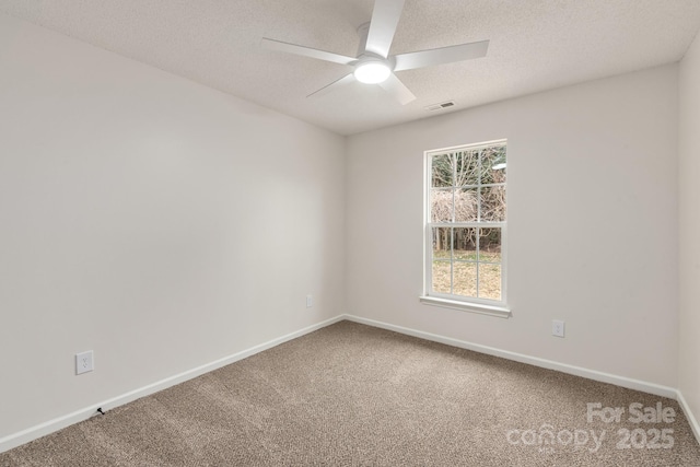 carpeted spare room featuring ceiling fan and a textured ceiling