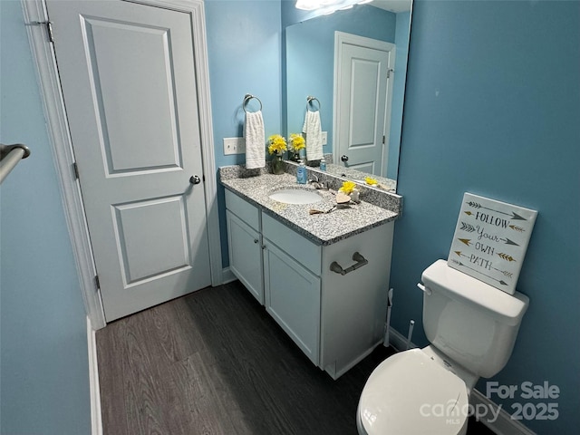 bathroom with hardwood / wood-style flooring, vanity, and toilet