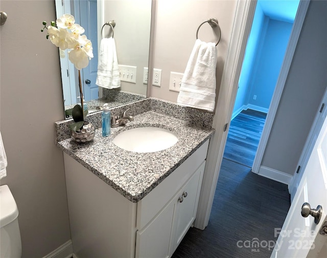 bathroom featuring hardwood / wood-style flooring, vanity, and toilet