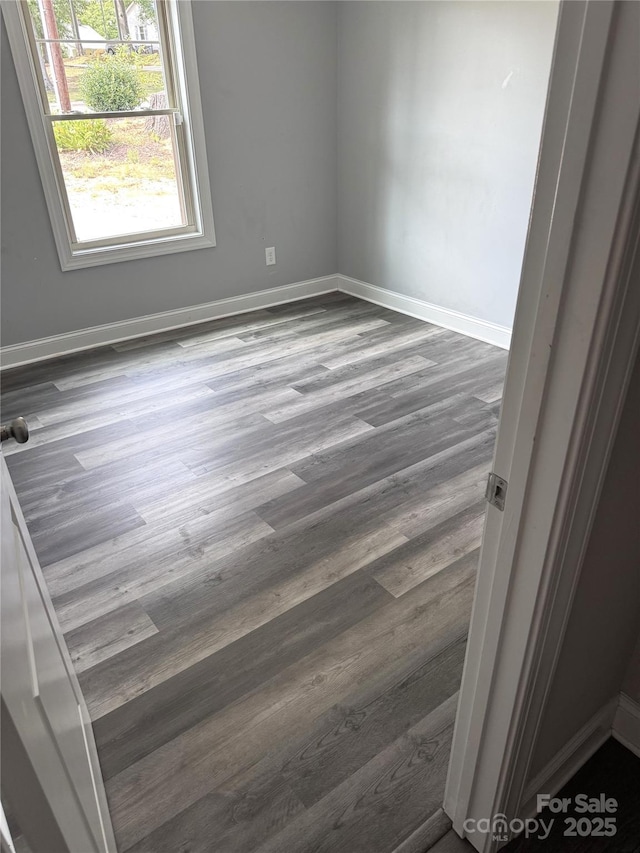 unfurnished room with dark hardwood / wood-style flooring