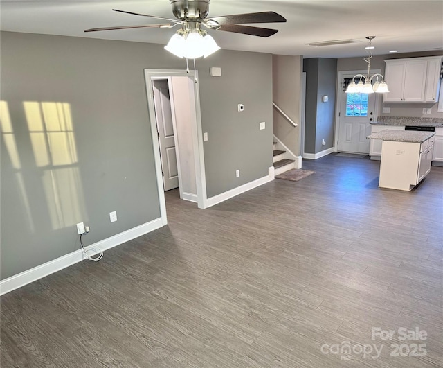 kitchen featuring pendant lighting, white cabinetry, dark hardwood / wood-style floors, a center island, and ceiling fan with notable chandelier