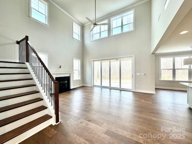 unfurnished living room featuring hardwood / wood-style flooring, a high ceiling, and a wealth of natural light