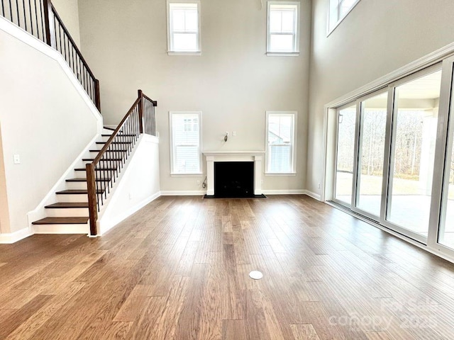 unfurnished living room featuring a healthy amount of sunlight and a towering ceiling