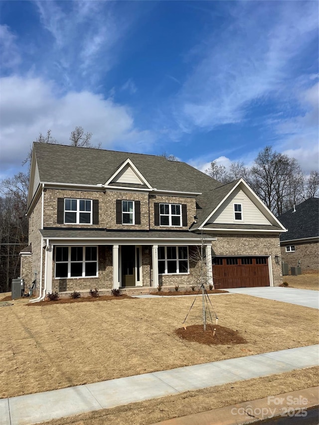 craftsman inspired home featuring a garage, central AC, and covered porch